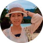 Asian woman smiling at camera at the beach